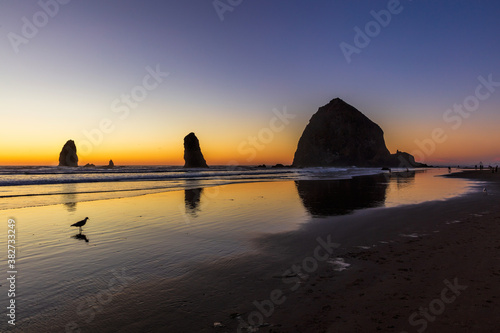 Dramatic sunset on the beach with Haystack rock and the needles photo