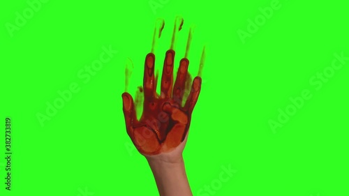 A hand covered in blood left a mark on the glass.On a neutral background, a person's hand leaves a bloody imprint. Concept for pre-rendered with green background. photo