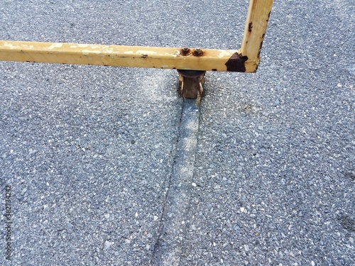 metal gate with groove in asphalt from friction