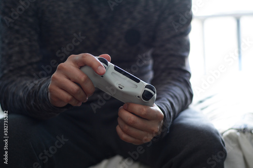 joven divirtiendose jugando videojuegos, persona sosteniendo un control de videojuegos, persona divirtiendose  photo