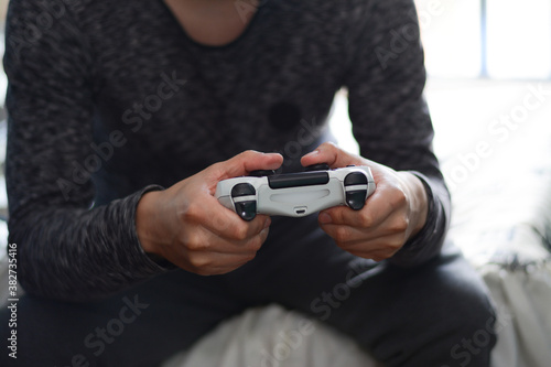 persona jugando videojuegos, persona sosteniendo un control de videojuegos, persona divirtiendose  photo