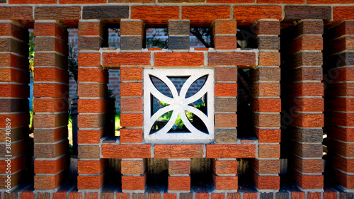 Red brick Wall with Floral Patterned Concrete Block in the Middle