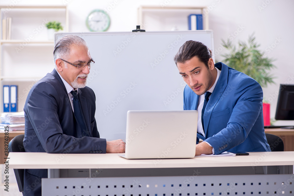 Yound and old employees in business presentation concept Yound and old employees in business presentation concept