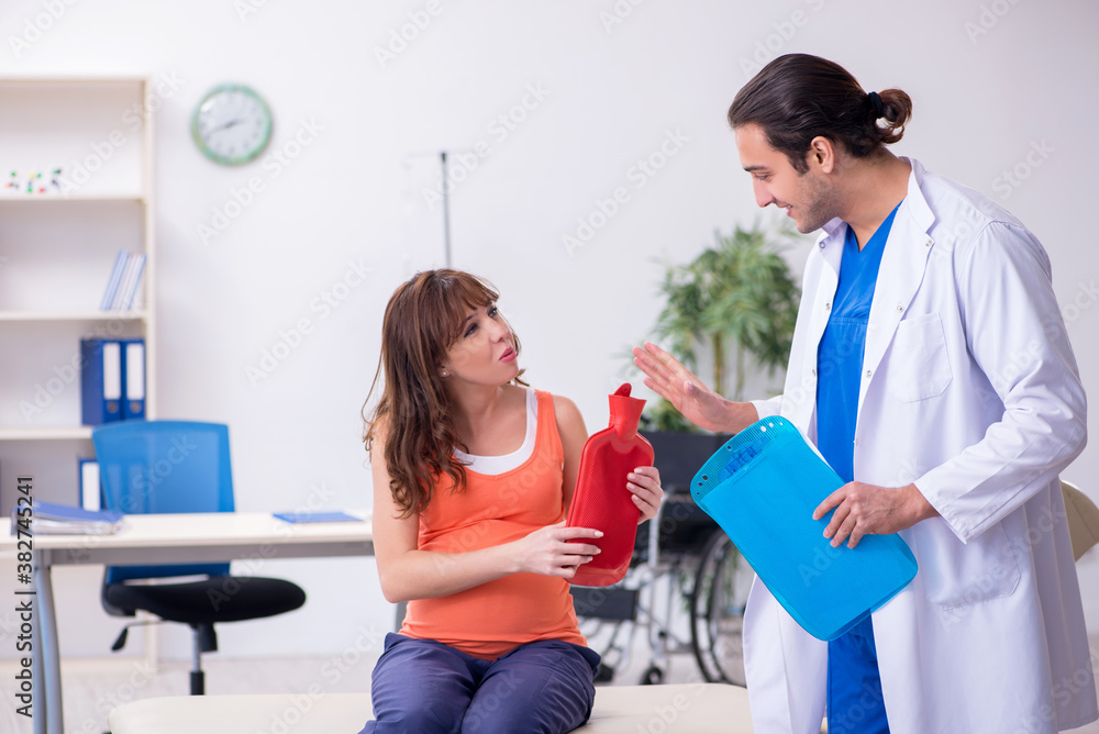 Fototapeta premium Pregnant woman visiting male doctor gynecologist