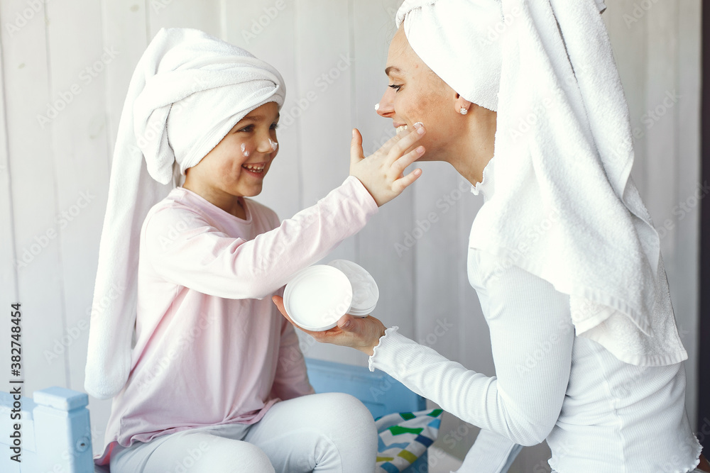 Obraz premium Little girl in a towel. Mother with daughter at home.