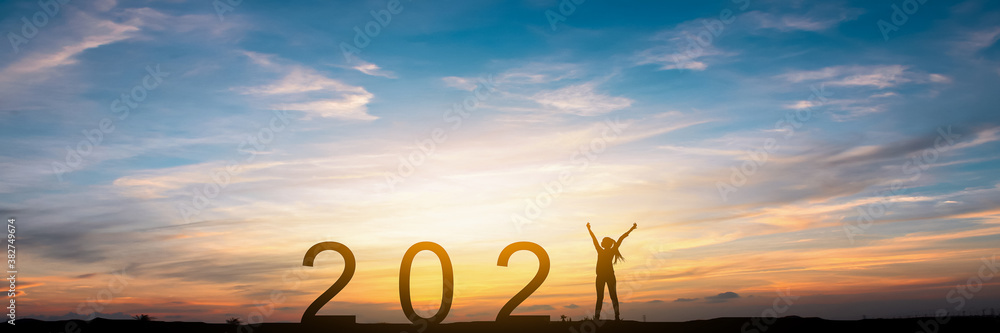 Silhouette of happy woman and 2021 concept in beautiful sunset sky background. - obrazy, fototapety, plakaty 