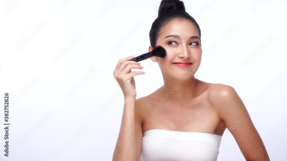 Glamour young woman smile and holding make-u brush with healthy clean and fresh skin while looking at camera over isolated white background. Beauty and cosmetics concept. Glamour young woman smile and holding make-u brush with healthy clean and fresh skin while looking at camera over isolated white background. Beauty and cosmetics concept.