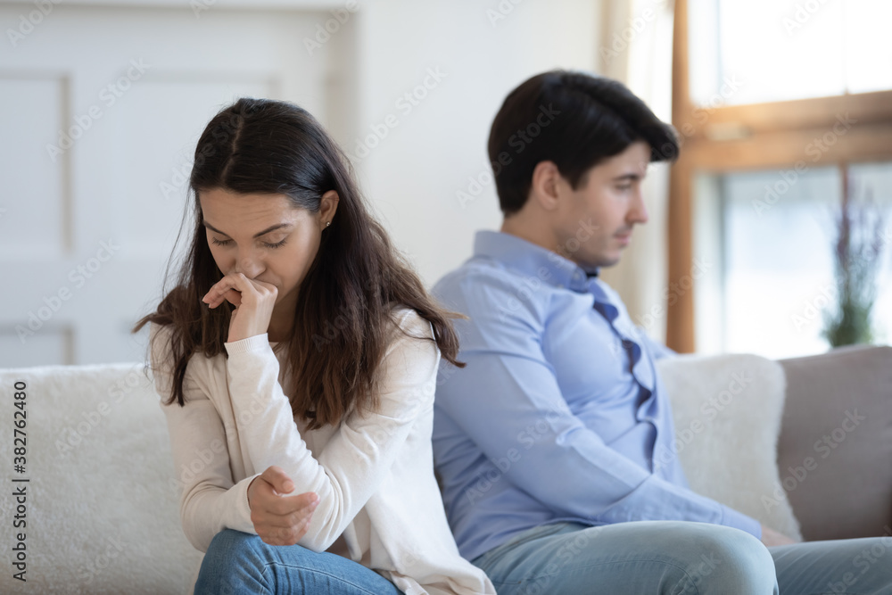 After quarrel. Indifferent insulted sad upset man and woman friends, lovers or spouses sitting on sofa turning away from one another avoid communicating and speaking, thinking about breakup or divorce After quarrel. Indifferent insulted sad upset man and woman friends, lovers or spouses sitting on sofa turning away from one another avoid communicating and speaking, thinking about breakup or divorce