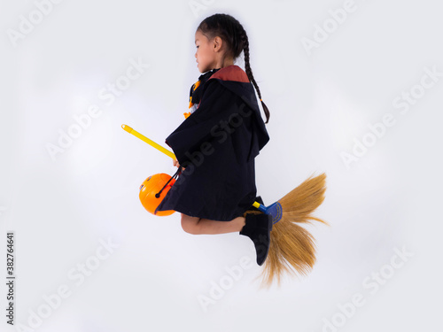 girl in witch dress costume Riding a broom on white background