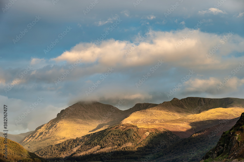 Stunning landscape image looking across Ennerdale Water in the English Lake District towards the peaks of Scoat Fell and Pillar during a glorious Summer sunset