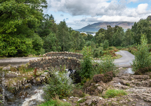 Stunning long exposure landscape image of Ashness Bridge in English Lake District during late Summer afternoon with dramatic lighting