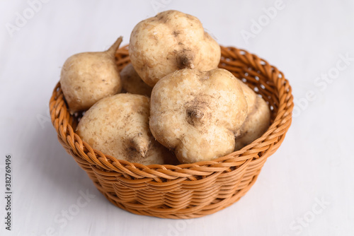 Fresh jicama or yam in a basket on white background