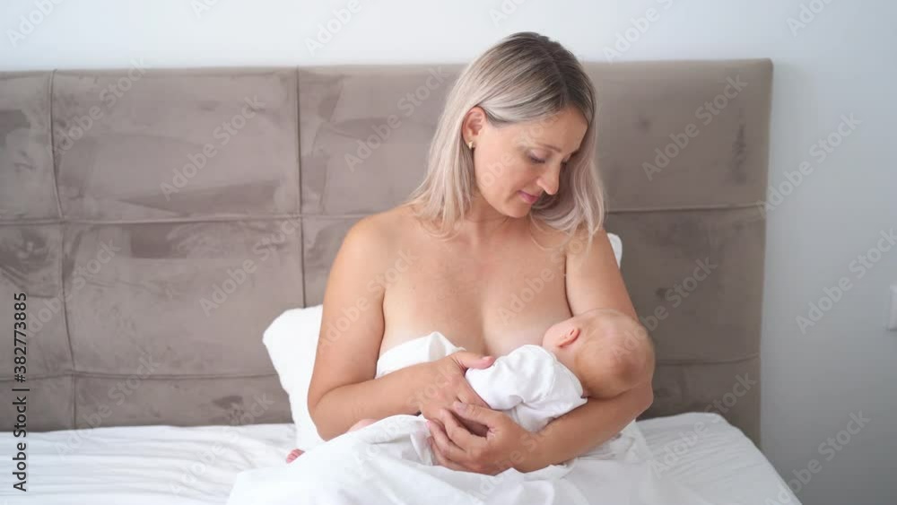 without clothes mom is sitting with baby feeding breast milk. breastfeeding without clothes mom is sitting with baby feeding breast milk. breastfeeding