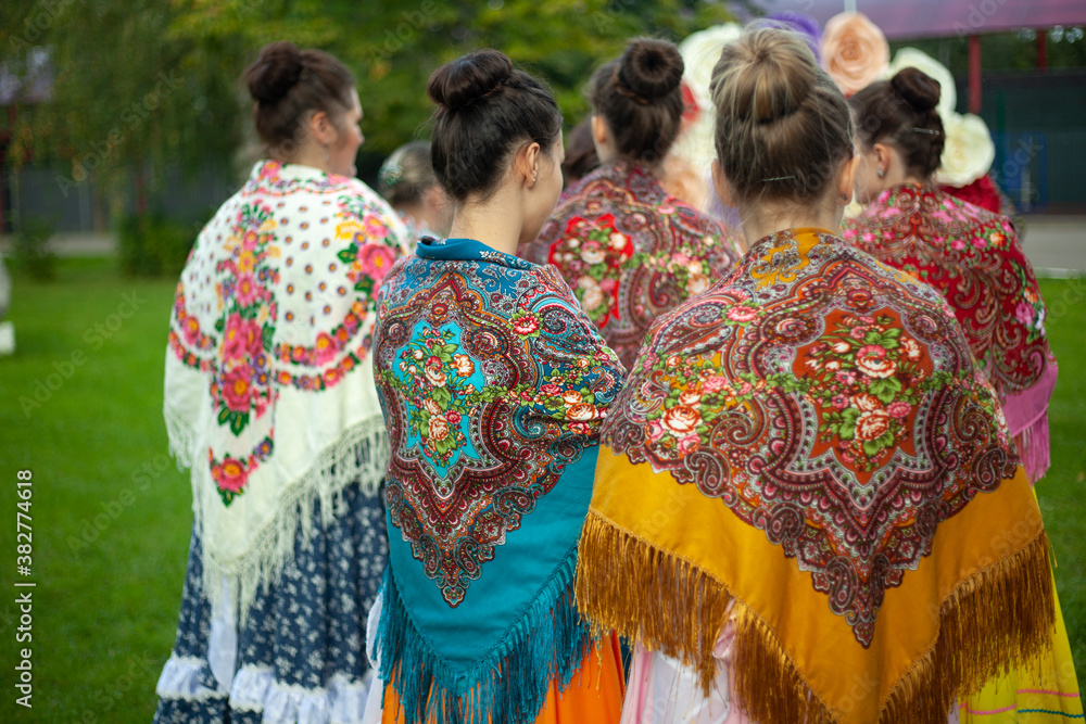 Obraz premium Folk scarves on the girls' shoulders. Russian traditional dress for women.