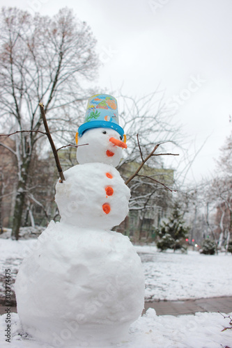 Snowman in the winter city park. Christmas holiday mood © Juver