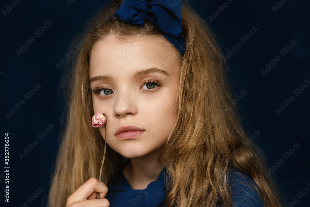Close up Art Portrait of Beautiful young girl 10-12 years old with blonde curly long hair, posing on blue background Close up Art Portrait of Beautiful young girl 10-12 years old with blonde curly long hair, posing on blue background