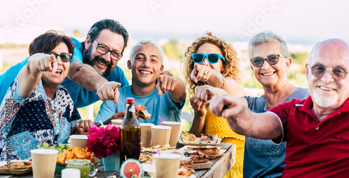 focus on hands - group of mixed ages family friends people enjoy and have fun together celebrating outdoor with table and food and drinks - cheerful caucasian men and women celebrating