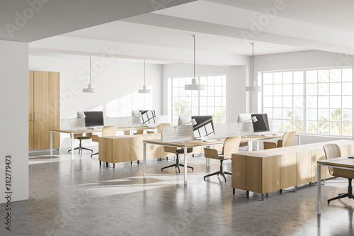 Modern white open space office corner with wooden tables