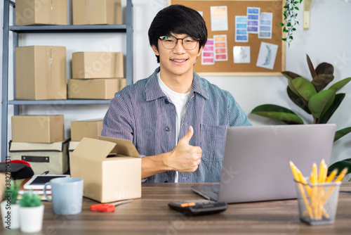 Asian man entrepreneur startup small business entrepreneur SME freelance man working with box to online marketing packaging and delivery scene at home office, onlinebusiness seller concept.