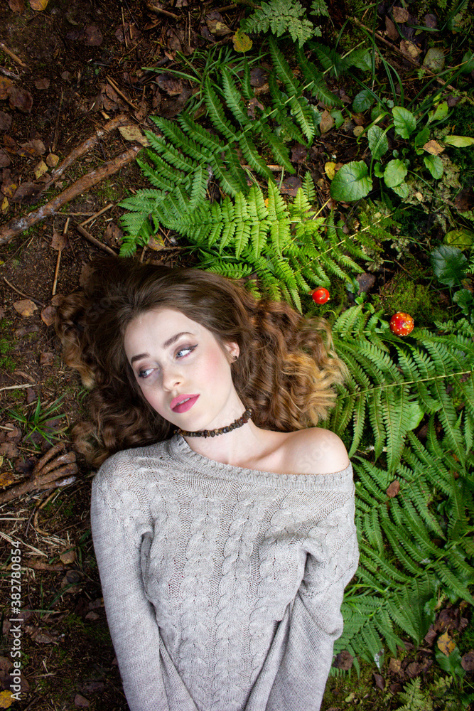 Gothic portrait. The girl lies on the grass. Girl in fern and amanita. Gothic portrait. The girl lies on the grass. Girl in fern and amanita.