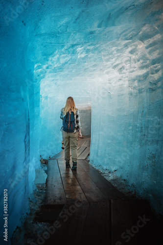  junge Frau läuft durch eine Eishöhle des Rhonegletschers in den Schweizer Alpen