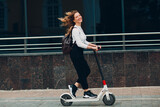 Young woman with electric scooter at the city