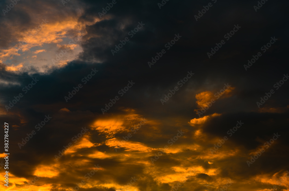 Beautiful sunset. Yellow and black clouds in the sky