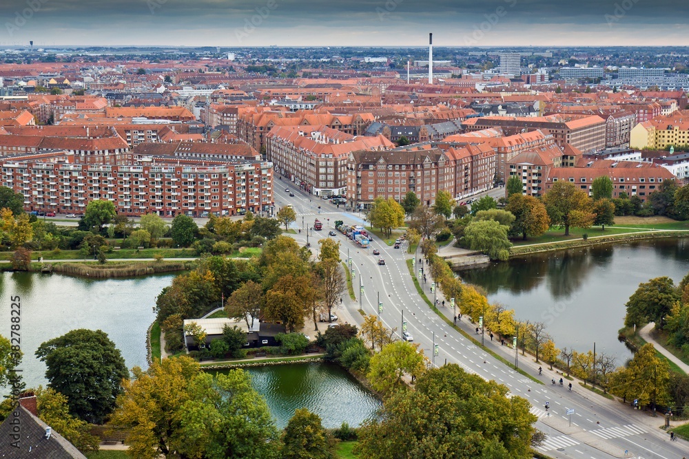 COPENHAGEN, DENMARK - OCTOBER 12, 2015. Copenhagen panorama taken from the Church of Our Savior on many red houses and a bridge with cars and trees in Christianshavn District, Denmark.