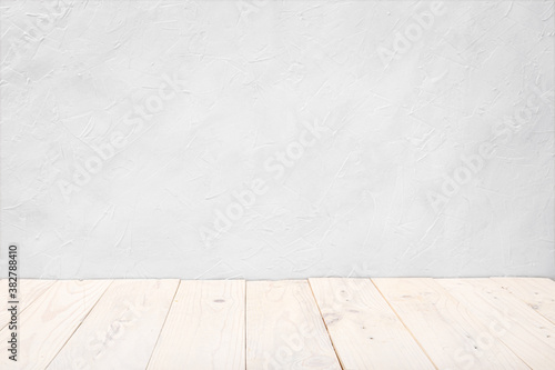 Empty wooden deck table over white textured wall background