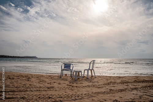 Chairs on the sandy seashore against the sky