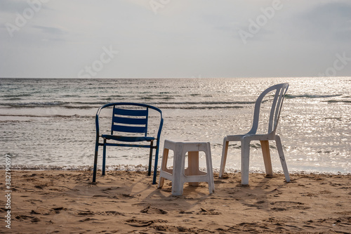 Chairs on the sandy seashore against the sky © Vitaliy