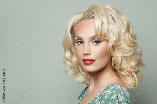 Cheerful blonde woman model with curly hair and makeup