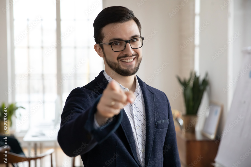 Close up portrait of smiling male employee point show at screen with finger meet welcome new candidate into team. Happy businessman offer suggest employment or internship, make choice gesture. Close up portrait of smiling male employee point show at screen with finger meet welcome new candidate into team. Happy businessman offer suggest employment or internship, make choice gesture.