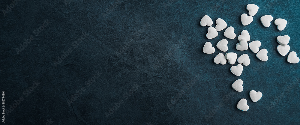 White medical pills in the form of hearts on a blue background. White medical pills in the form of hearts on a blue background.