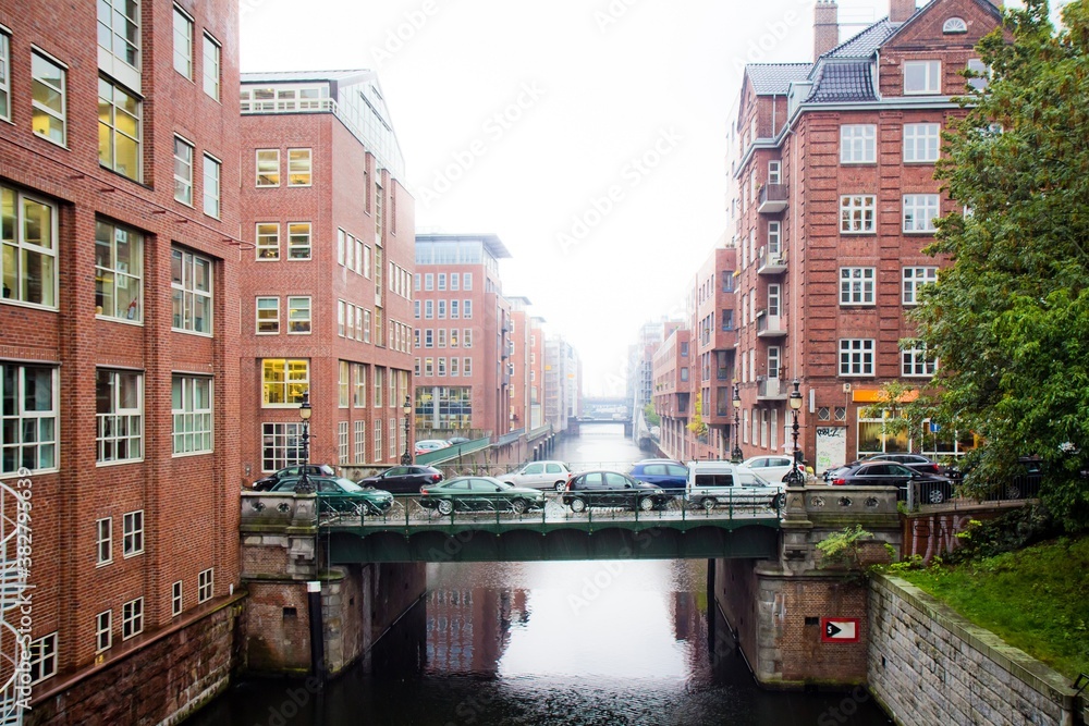 HAMBURG, GERMANY - OCTOBER 15, 2015. A bridge over the canal with plenty cars and surrounding red brick buildings in spring in Hamburg, Germany.