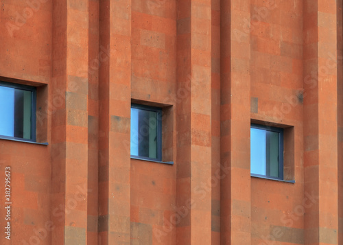 Texture of terracotta brick wall with parallel pattern and windows