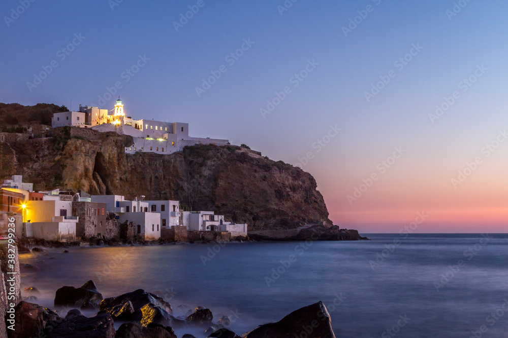 Nisyros, Greeec. Sunset in Mandraki village, the capital town of Nisyros island,Greece. In the background is the monastery of Panagia Spiliani.