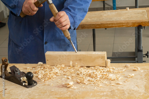 Grey man works chime on wood. carpenter's job. Hobby at 60