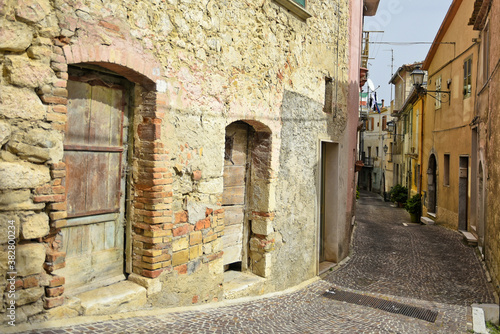 Fototapeta Naklejka Na Ścianę i Meble -  A narrow street among the old houses of Mirabello Sannitico, a medieval village in the province of Campobasso, Italy