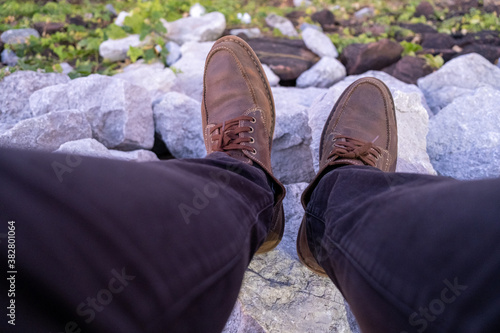 Top view of leather shoes standing on stone mountain.