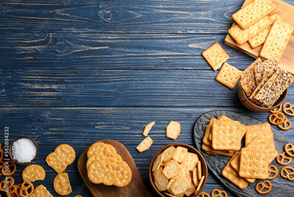 Many delicious crackers on blue wooden table, flat lay. Space for text Many delicious crackers on blue wooden table, flat lay. Space for text