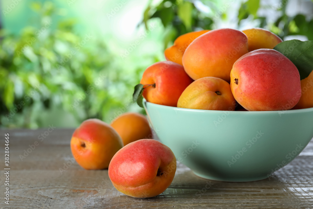Many fresh ripe apricots on wooden table against blurred background Many fresh ripe apricots on wooden table against blurred background