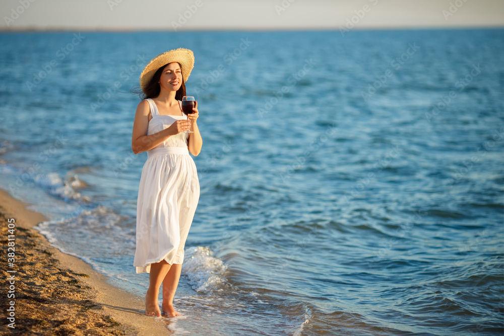 woman holding glass of wine by the sea woman holding glass of wine by the sea