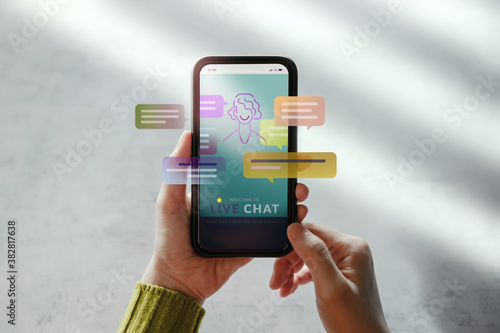 LiveChat Technology Concept. Customer Using Mobile Phone To Make Conversation with an Artificial Intelligence . Virtual Assistant for Customer Support Information