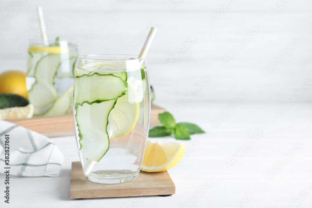 Fototapeta premium Refreshing water with cucumber, lemon and mint on white table