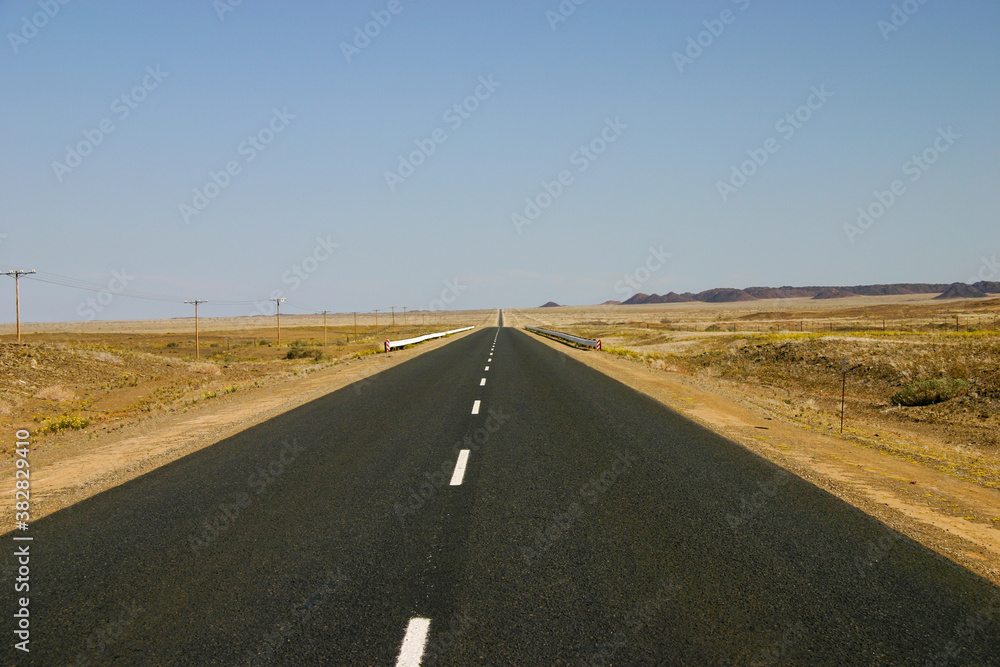 A long paved road stretches to a distant horizon