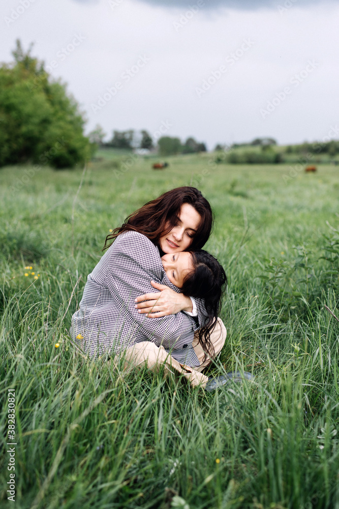 Vacation, wanderlust, travelling. Woman with daughter on green grass. Family, love, trust. Mothers day concept friend Vacation, wanderlust, travelling. Woman with daughter on green grass. Family, love, trust. Mothers day concept friend