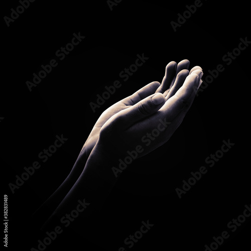 Ramadan kareem concept: Black and white muslim prayer open two empty hands with palms up on dark room background