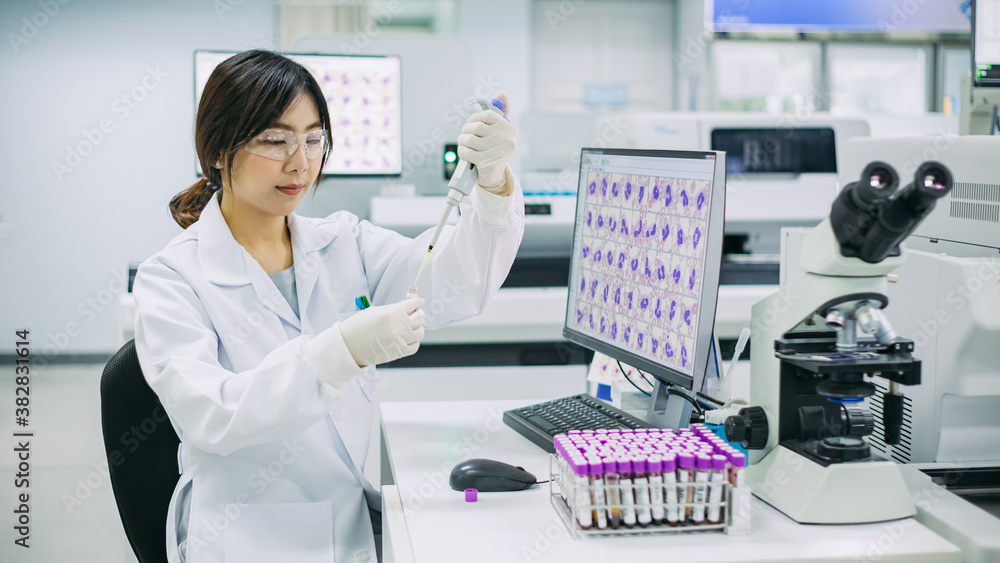 Young expert medical technologist working by pipetting skill with blood
