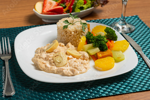 Delicious healthy food with chicken stroganoff with rice and potatoes vegetables on the plate.